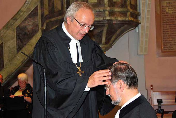 Bischof Michael Bünker segnet Superintendent Hermann Miklas bei seiner Amtseinführung.
