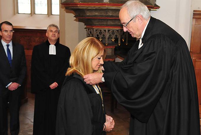 Bischof Michael Bünker überreicht der neuen Oberkirchenrätin Ingrid Bachler das Amtskreuz. Foto: epd/Uschmann