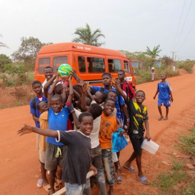 Kinder zeigen ihren neuen Fußball in Ghana