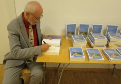 Der Autor, Martin Friedrich, signiert das neue Buch über die Entwicklung der Gemeinschaft Evangelischer Kirchen in Europa. (Foto: GEKE/Monjencs)