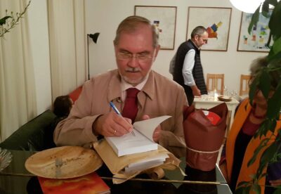 Hermann Miklas signiert beim Krimi-Salon Exemplare seines Buches „Wenn die Vergangenheit Schatten wirft“. (Foto: epd/M. Link)