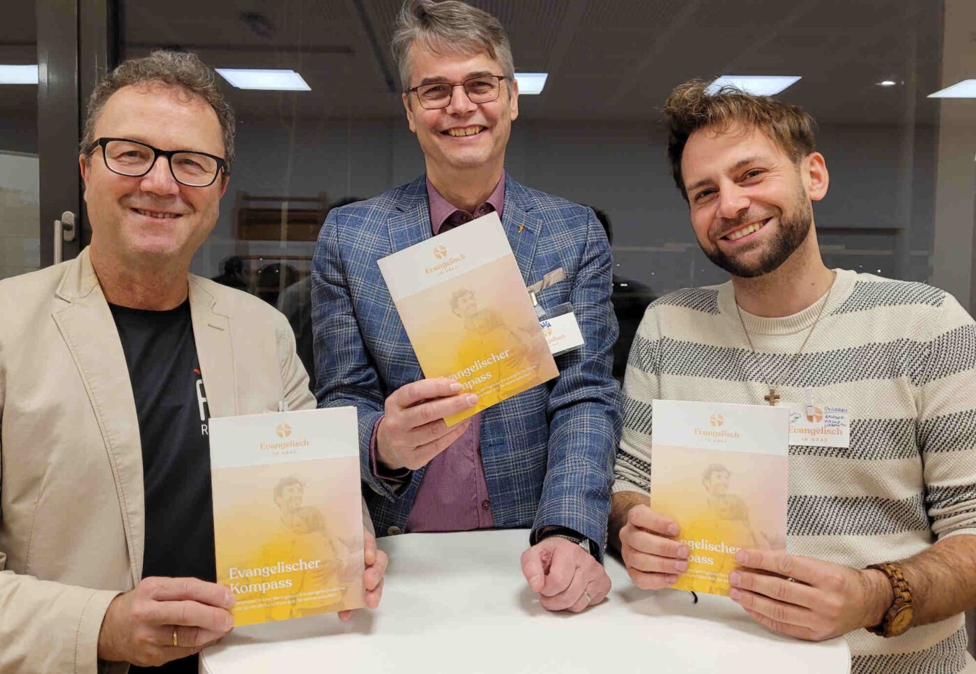 Georg Plank von Pastoralinnovation, Superintendent Wolfgang Rehner und Pfarrer Marcus Hütter präsentieren den neuen „Evangelischen Kompass“ in Graz. Foto: epd/Trojan