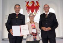 Gerlinde Busse nach der Auszeichnung durch die Landeshauptmänner Arno Kompatscher (l.) und Anton Mattle (r.). (Foto: Land Tirol/Die Fotografen)